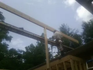 Carpenter setting a ridge beam over a new addition frame — Ice Dam Removal by Roofing Brothers in Kent